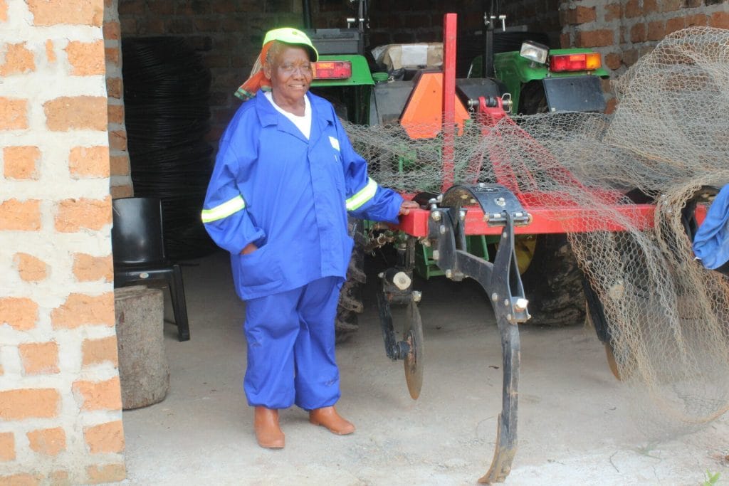 Zambian farmer, Caroline Mwela stands next to her John Deere tractor that will help cultivate 30 hectares of her land.