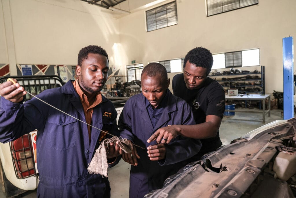 Transparency Auto Workers Cooperative Members inspecting a car's oil level.