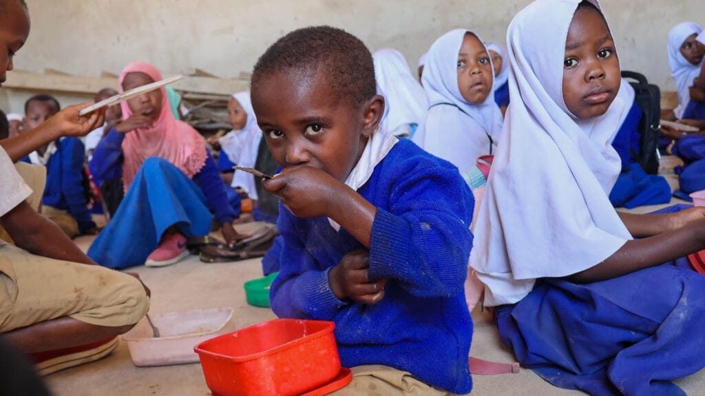 Student in Tanzania eating a school meal