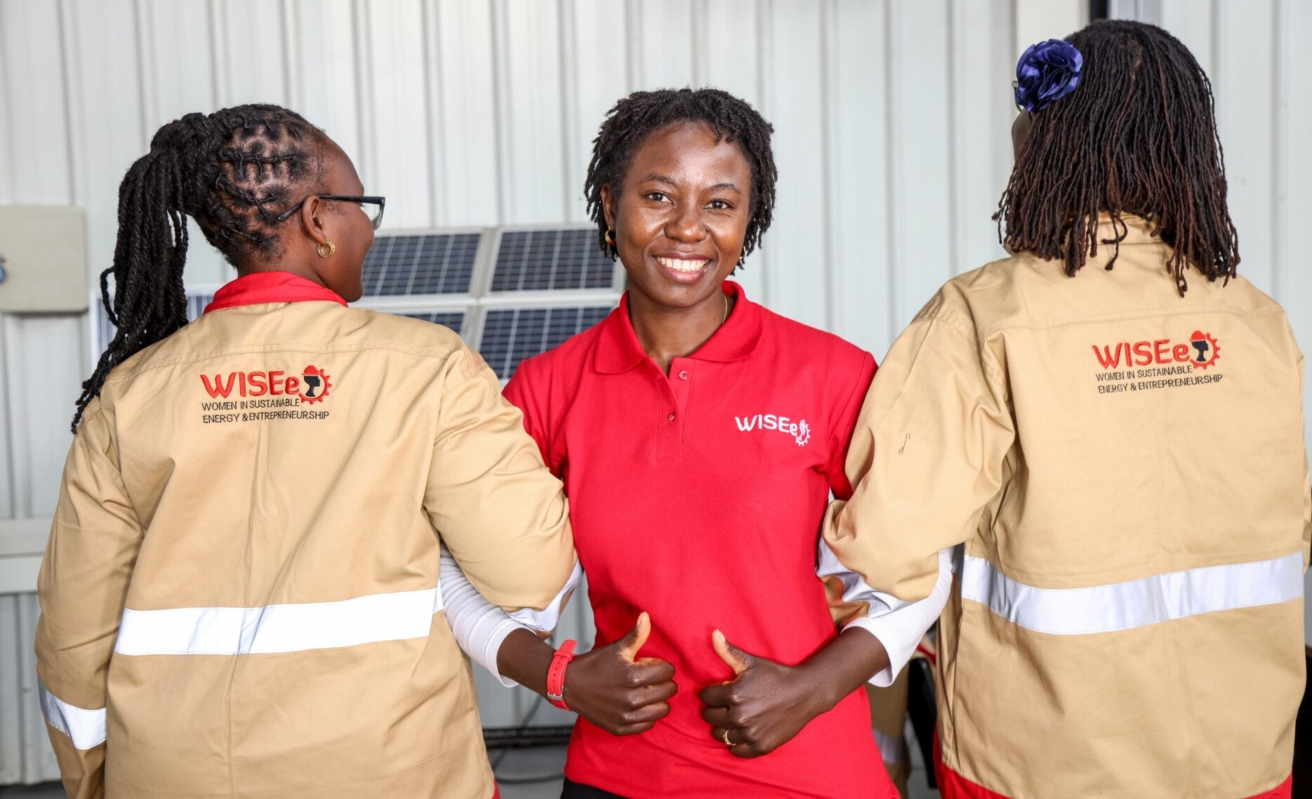 WISEe members smiling and showing their uniforms.